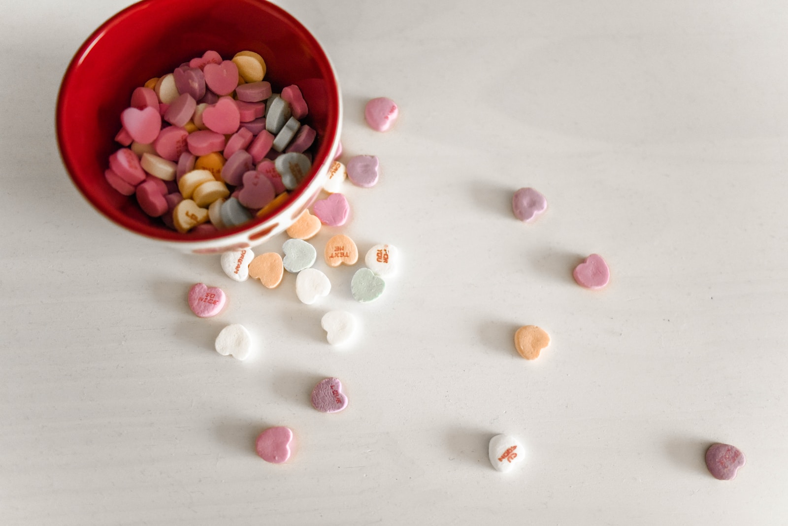 assorted-color candies and red and white ceramic bowl