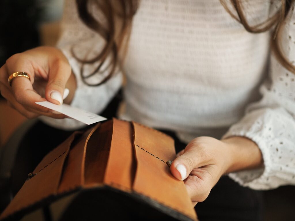 a woman holding a wallet and a piece of paper